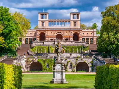 Frederick the Great monument with Orangery at background in Sanssouci park, Potsdam, Germany