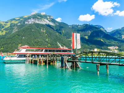 Tourist ship mooring at pier on shore of Achensee lake on sunny summer day, Pertisau, Tirol, Austria