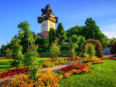 The medieval Clock tower Uhrturm in flower garden on Shlossberg hill, Graz, Austria